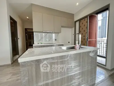 Modern kitchen with island and balcony view in new apartment