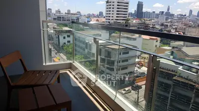 Stunning city view from modern balcony with glass railing and wooden seating.
