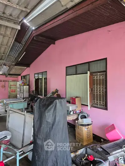 Spacious outdoor area with pink walls and ample storage space, ideal for creative renovations.