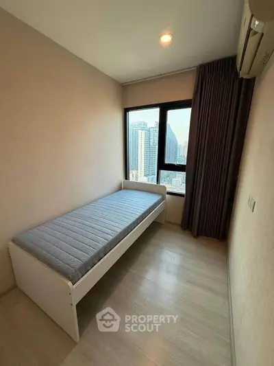 Cozy bedroom with single bed and city view in modern apartment