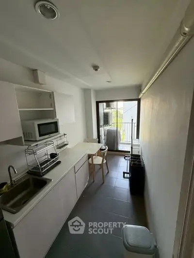 Compact kitchen with modern appliances and balcony access