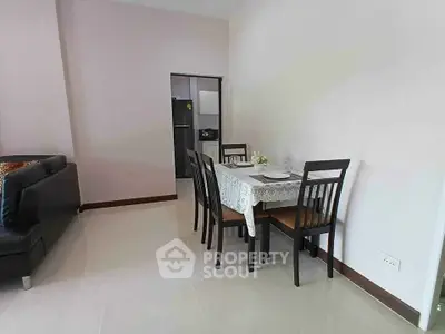 Modern dining area with elegant table setting and sleek black chairs in a cozy apartment.