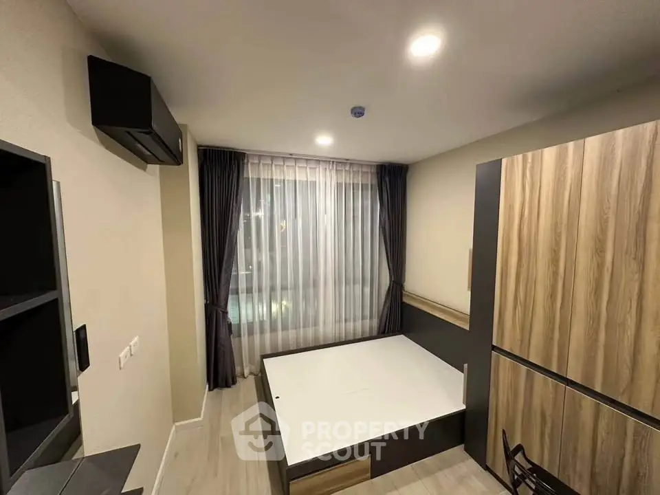 Modern bedroom with stylish wooden furniture and large window with curtains