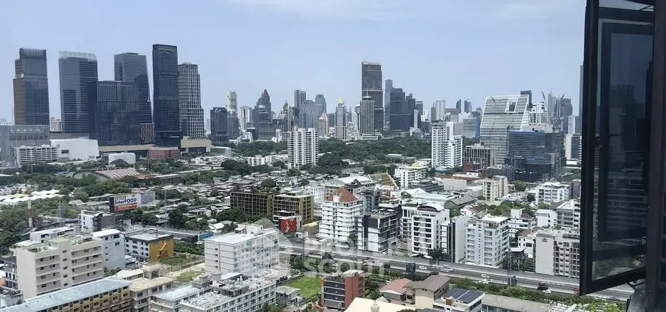 Stunning cityscape view from high-rise apartment balcony overlooking urban skyline.