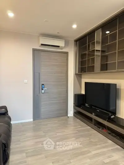 Modern living room with sleek TV setup and built-in shelving, perfect for entertainment.