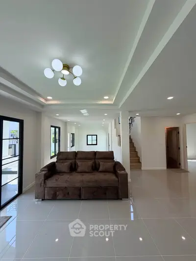 Spacious modern living room with elegant lighting and large windows for natural light.
