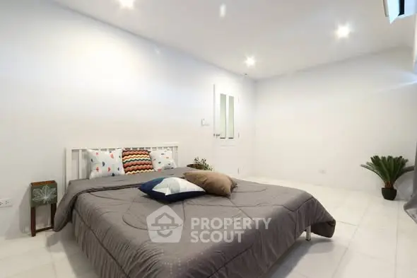 Spacious minimalist bedroom with cozy bedding and modern decor