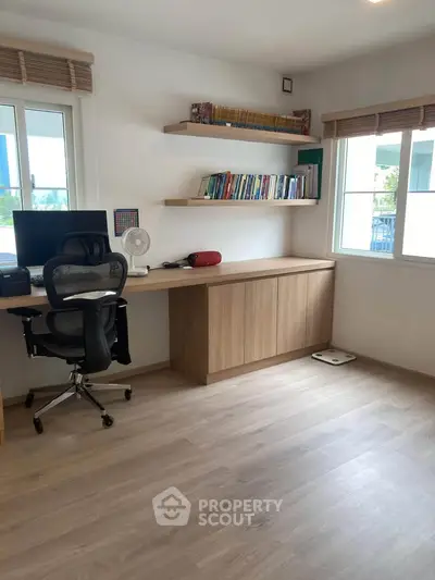 Modern study room with sleek desk, ergonomic chair, and natural light from large windows.