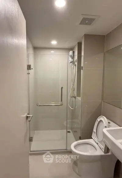 Modern bathroom with glass shower enclosure and sleek fixtures