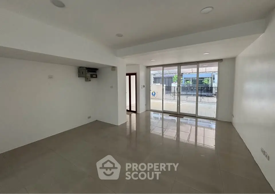 Spacious unfurnished room with large windows and glossy tiled floors