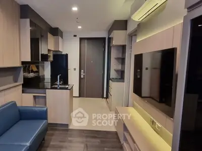 Modern living room with sleek kitchen and stylish furnishings in a contemporary apartment.