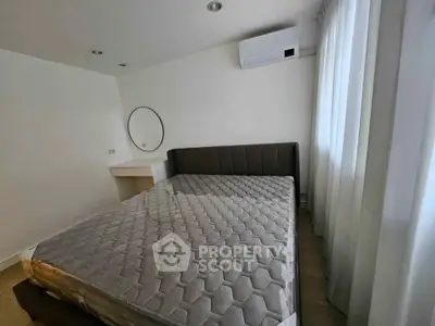 Spacious bedroom with modern decor and large window for natural light.