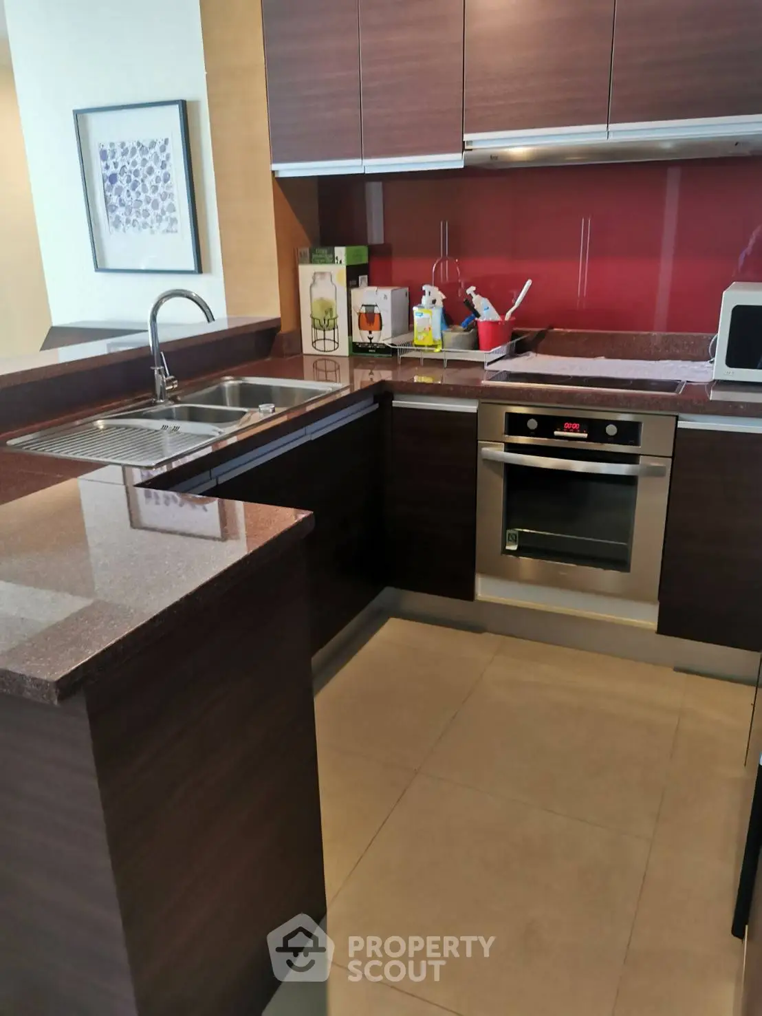 Modern kitchen with sleek cabinetry and built-in oven, featuring a stylish open layout and contemporary design.