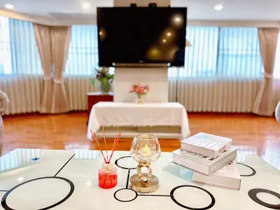 Spacious living room with modern decor and large TV, perfect for relaxation.