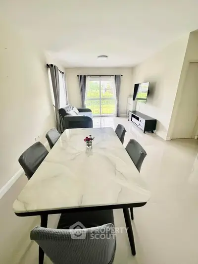 Spacious modern living room with elegant dining area and large windows for natural light.