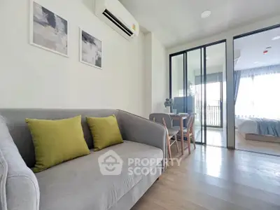 Modern living room with cozy sofa and stylish decor leading to a bright bedroom.