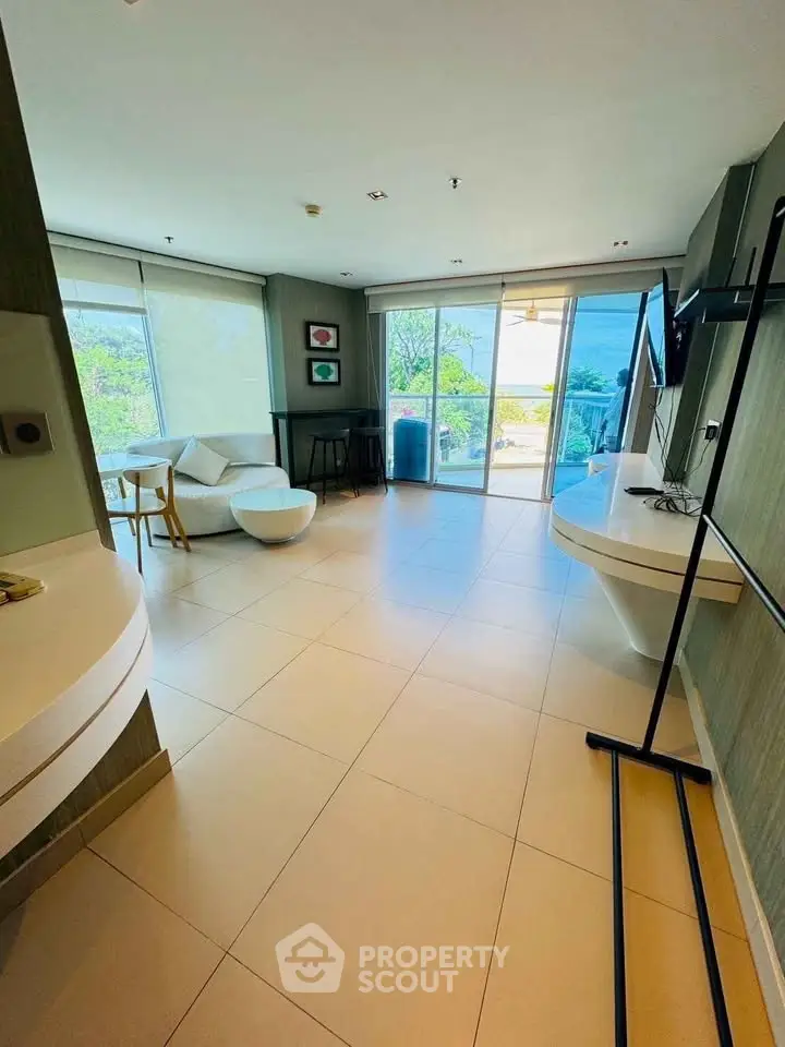 Spacious modern living room with large windows and balcony view