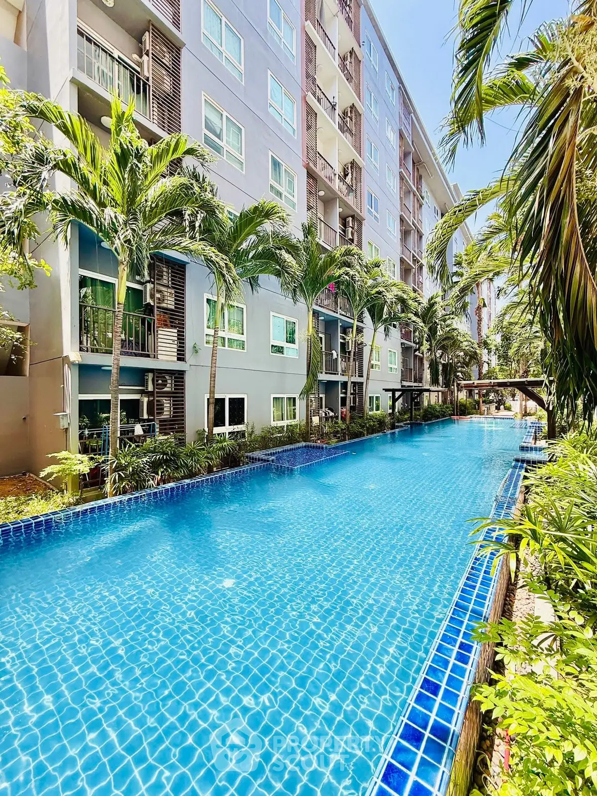 Luxurious apartment complex with stunning pool and lush greenery, perfect for relaxation and leisure.