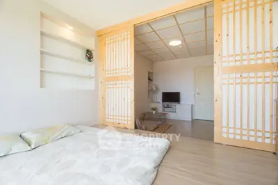 Spacious Japanese-style living room with sliding doors and cozy futon bedding.