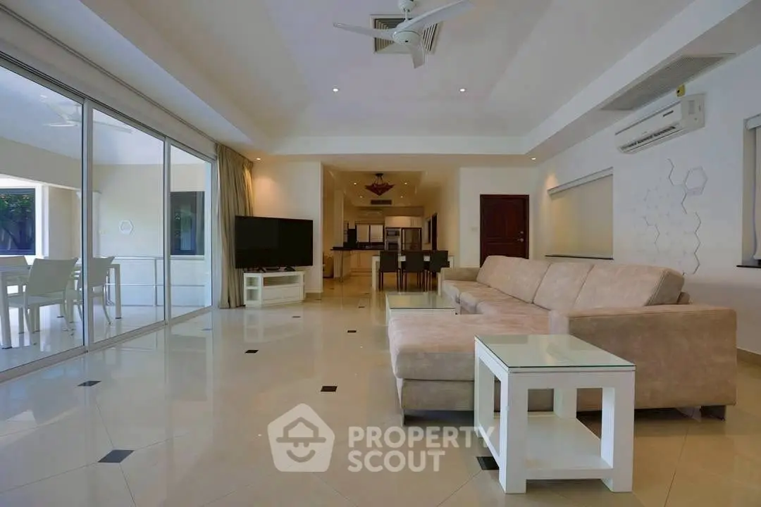 Spacious modern living room with large windows and elegant furnishings.