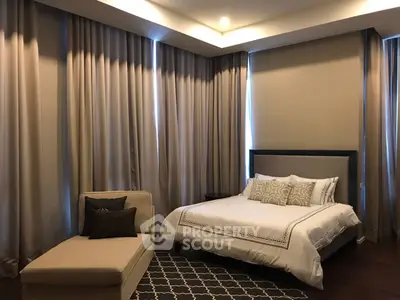 Luxurious bedroom with elegant drapes and cozy chaise lounge