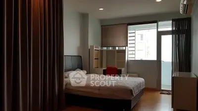 Spacious bedroom with modern decor and balcony access in a stylish apartment.