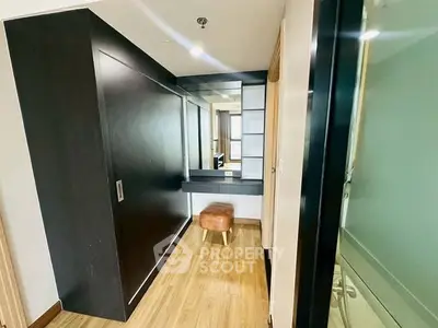 Modern interior hallway with sleek black cabinetry and wooden flooring