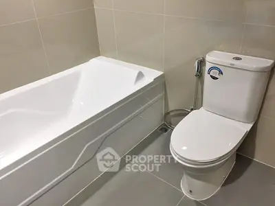 Modern bathroom with sleek bathtub and toilet in contemporary design.
