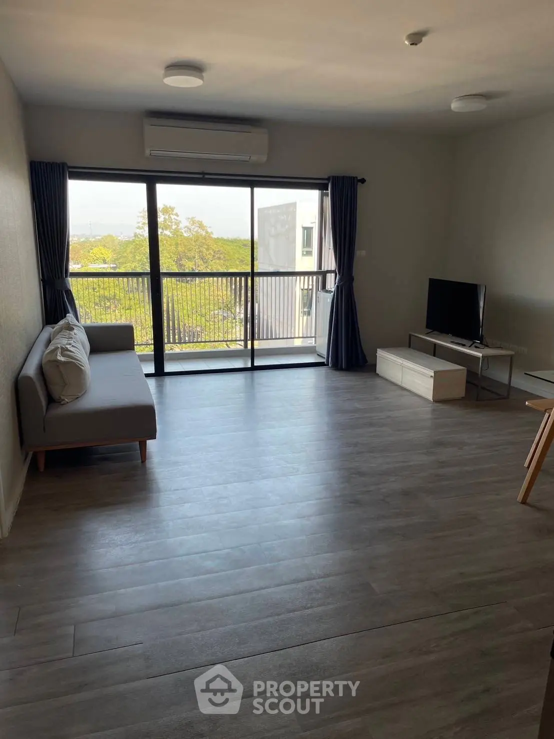 Spacious living room with modern decor and large window offering scenic views.