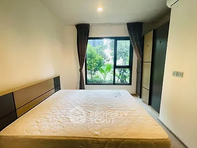 Cozy bedroom with large window and garden view, featuring a comfortable bed and modern decor.