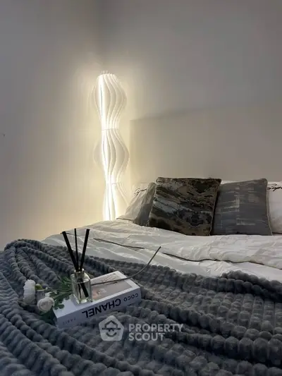 Cozy bedroom with modern lighting and plush bedding for ultimate relaxation.