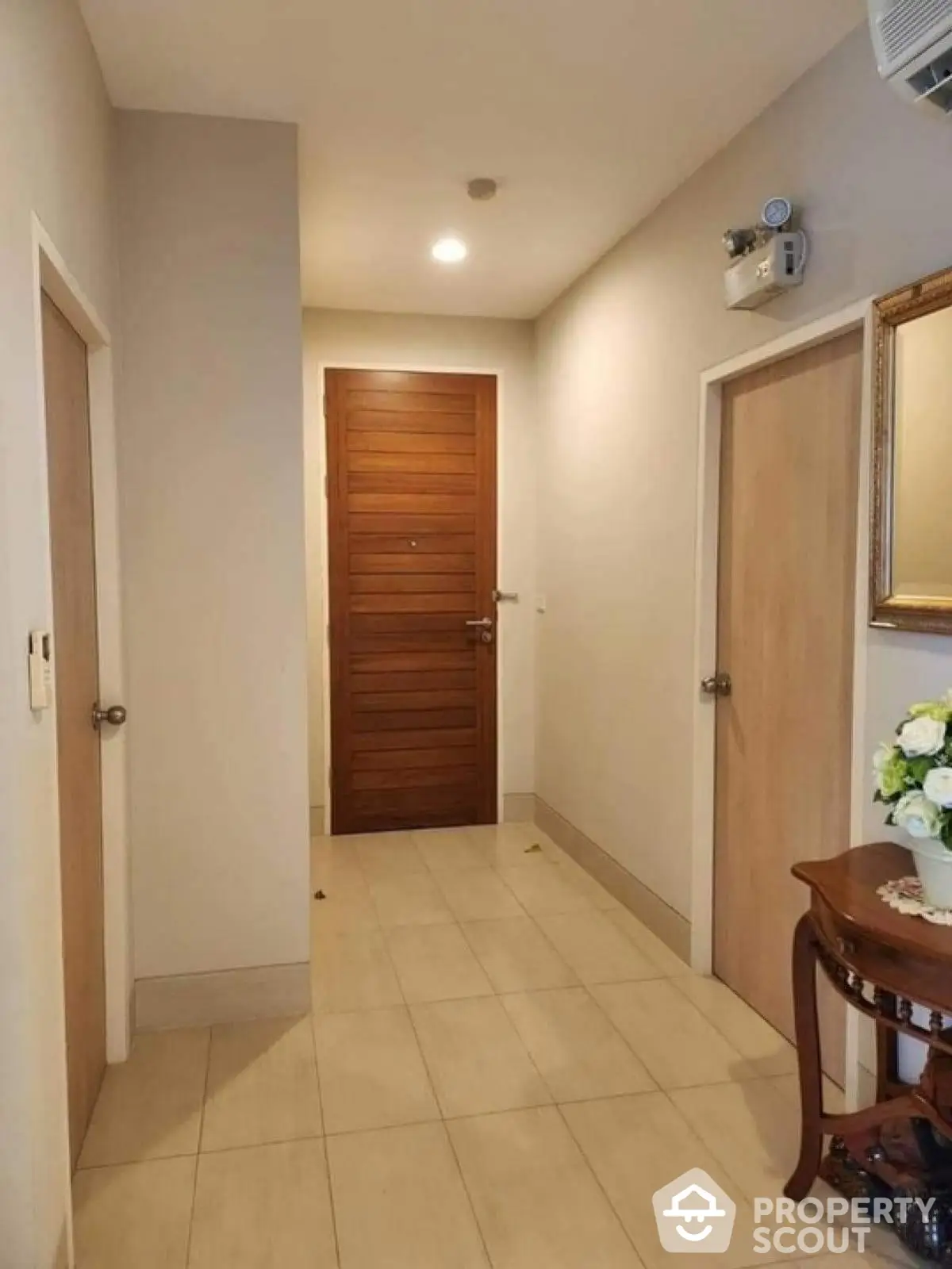 Elegant apartment entrance with wooden doors and tiled flooring