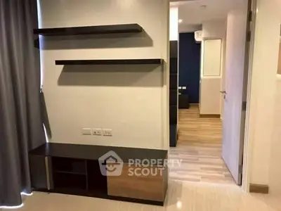 Modern apartment interior with wooden flooring and sleek shelving unit.