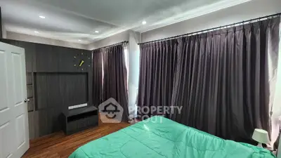 Spacious bedroom with modern decor and large windows for natural light.