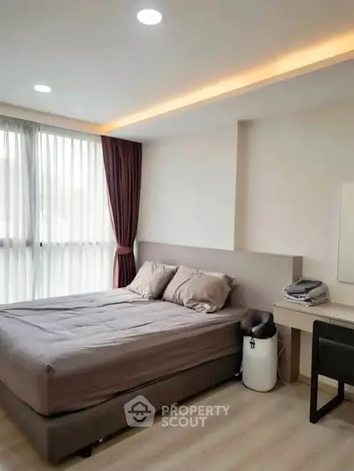 Modern bedroom with cozy bed, stylish lighting, and elegant curtains in a contemporary apartment.