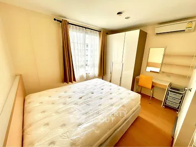 Bright and cozy bedroom with large window and modern furnishings in a stylish apartment.