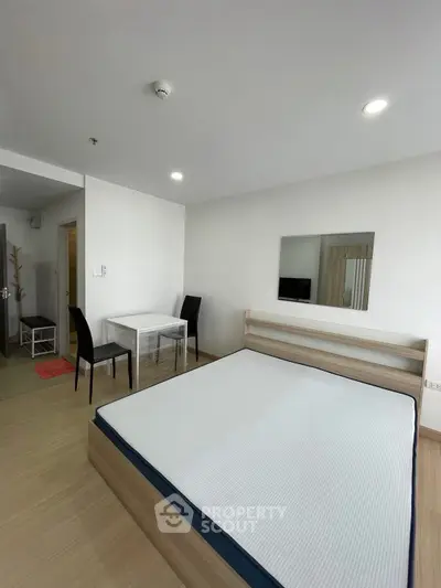 Modern bedroom with minimalist design and cozy dining area in a stylish apartment.