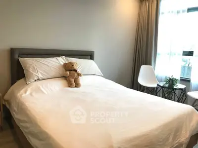 Cozy bedroom with plush bedding and natural light, featuring a charming teddy bear on the bed.