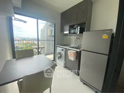Modern kitchen with balcony view, featuring sleek appliances and dining area in a stylish apartment.