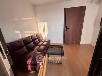 Cozy living room with leather sofa and modern coffee table, perfect for relaxation.