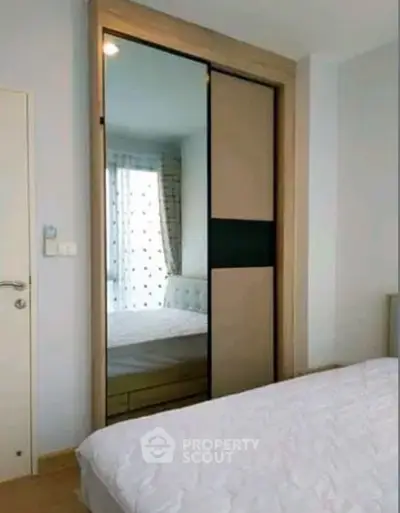 Modern bedroom with mirrored sliding wardrobe and stylish decor