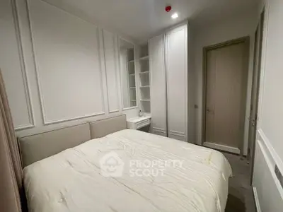 Cozy bedroom with elegant white paneling and built-in storage in modern apartment.