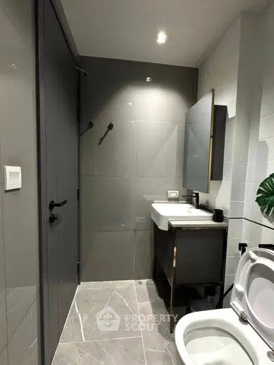 Modern bathroom with sleek design, featuring a stylish sink and toilet, perfect for contemporary living.