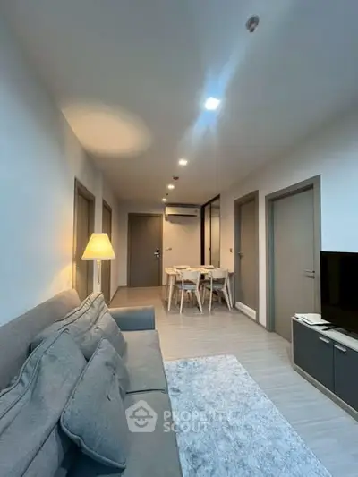 Modern living room with cozy seating and dining area in stylish apartment.