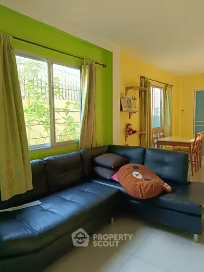 Charming living room with vibrant green walls and cozy sectional sofa