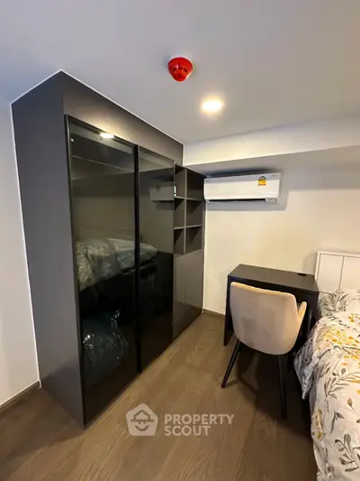 Modern bedroom with sleek wardrobe and cozy workspace