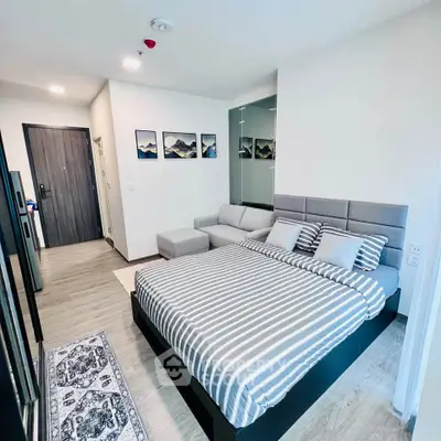 Modern bedroom with stylish decor and cozy seating area in a contemporary apartment.