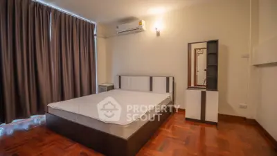 Spacious bedroom with modern furniture and wooden flooring