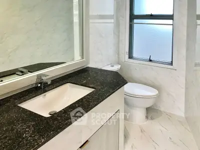 Modern bathroom with sleek marble finishes and large mirror