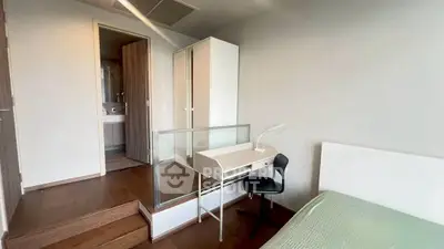 Modern bedroom with study area and ensuite bathroom in sleek apartment